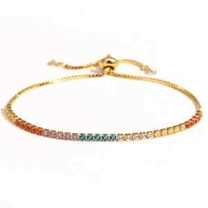 Detail of colorful gradient gemstones on a gold adjustable bracelet with slider clasp