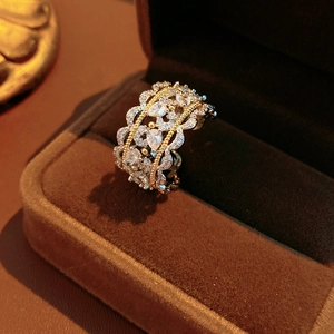 Macro detail of a wide hollow lace ring with pear-cut zircon in a brown velvet box