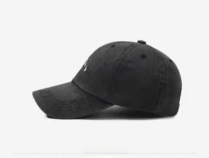 Detailed side profile of a dark grey washed cotton baseball cap with mountain embroidery