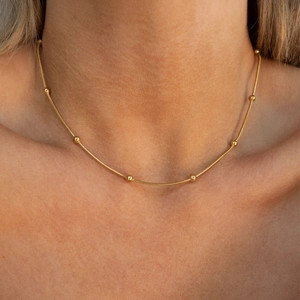 Elegant gold snake chain necklace with small round beads for a minimalist layered look
