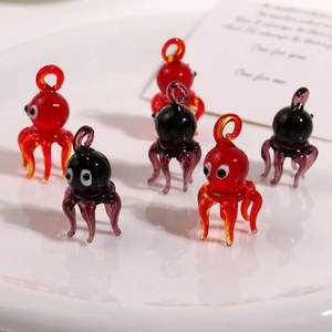 Macro shot of 3D octopus glass pendants in red and purple for DIY jewelry making