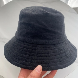 Close-up of the black terry cloth bucket hat showing its soft fuzzy texture and thick fabric