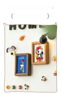 Detail of walnut wood magnetic photo frames with cartoon art on white background
