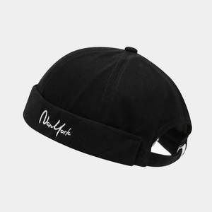 Close-up of the white New York embroidery and adjustable metal buckle on a black docker hat
