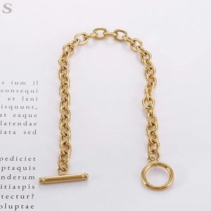 Detail of a polished gold-tone stainless steel chain bracelet with a classic T-bar OT clasp