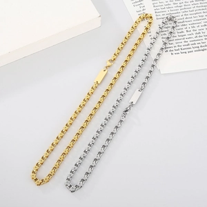 Detail of square link titanium steel necklaces in gold and silver with logo plates