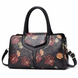 Detail of vintage floral print pillow bag with stitched Y-pattern and gold hardware