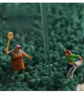 Macro detail of plush green bath mat surface with creative miniature figures showing high water absorption