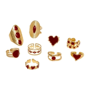 9-piece set of gold vintage stainless steel rings with red enamel hearts on white background
