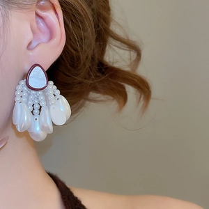 Detail of vintage red triangle earrings with elegant multi-layer pearl tassels and teardrops