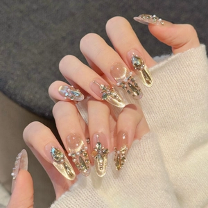 Champagne cat eye press-on nails with luxury rhinestones and pearls on a long oval shape