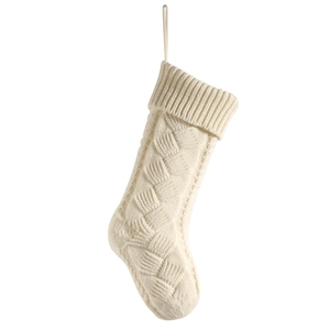 White cable knit Christmas stocking with hanging loop on a plain white background