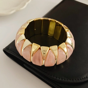 Detail view of pink marble resin tiles and golden metal frame on elastic cuff bracelet