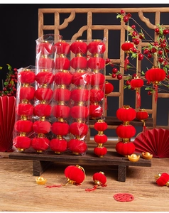 Close-up of red flocked mini lanterns on a wooden rack with Chinese festive background