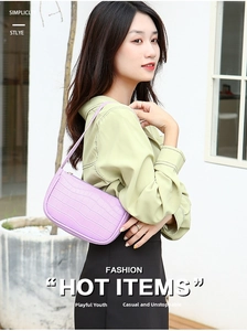 Detail view of purple crocodile embossed leather hobo bag worn with light green shirt