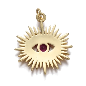 Macro view of gold sunburst pendant with evil eye design and red zircon stone
