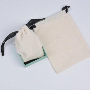 Close-up of beige cotton jewelry drawstring bags with black ribbons in a gift box