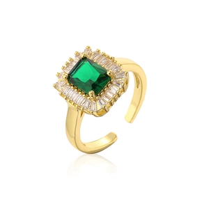 Close-up of gold plated ring featuring emerald cut green zircon and rectangular white stones