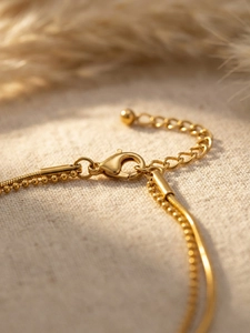 Detail of gold double-layer snake and bead chain bracelet with lobster clasp and extender