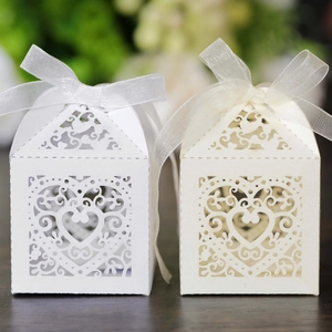 Detail of laser-cut heart pattern on white gift boxes with delicate organza ribbons