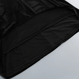 Detail of elegant black velvet dress showing premium texture and fine hemline stitching