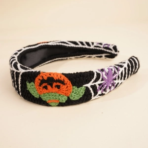 Detail view of Halloween knitted headband featuring orange pumpkin and purple spider embroidery