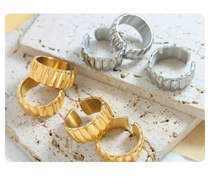 Close-up of gold and silver plated chunky ribbed croissant rings on stone plate