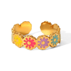 Detail of gold-plated stainless steel ring featuring colorful enamel daisy floral patterns