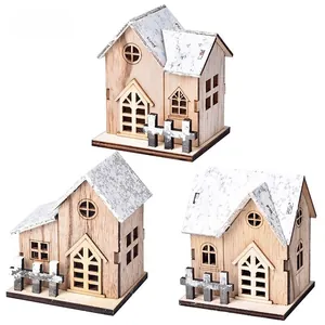 Detailed view of three-piece set wooden Christmas houses with snowy roof and fence