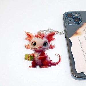 Acrylic Christmas dragon ornament with gift box and smartphone for size reference