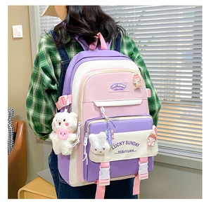Detail view of purple and pink school backpack with cute plush bear and rabbit pendants