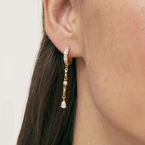 Élégantes boucles d'oreilles pendantes dorées avec pampilles en zircons sur mannequin