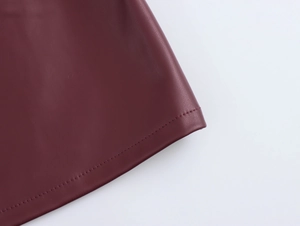 Detail view of the stitching and leather texture on the dark red PU leather tank top