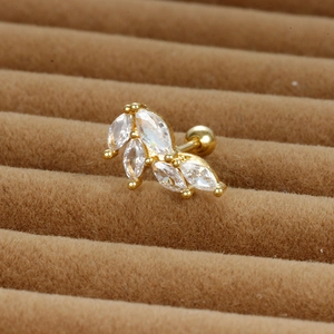 Vue macro d'un piercing hélix en acier doré avec zircons en forme de feuilles