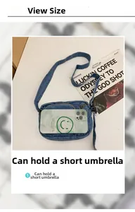 Detail view of denim crossbody bag showing capacity for a smartphone and a short umbrella