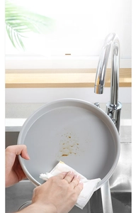 Macro shot of easy-to-clean round gray spice tray being wiped clean in a modern kitchen
