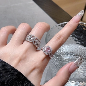 Sparkling silver ring set with pink square zircon and hollow rose design on hand