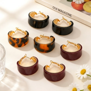 Three pairs of thick hoop earrings in leopard print, black and burgundy with gold accents