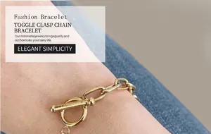 Detailed close-up of gold paperclip chain bracelet with a classic toggle OT clasp on wrist