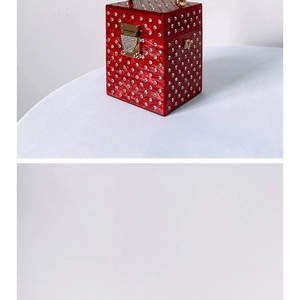 Detail of red acrylic evening clutch with sparkling rhinestones and gold metal clasp