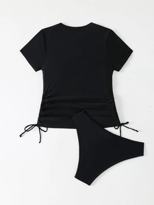 Detail of black two-piece tankini swimsuit with side drawstring ruching on short sleeve top