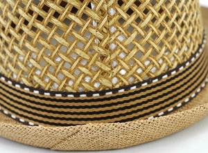 Close-up of natural straw weave and striped decorative ribbon on a summer fedora hat