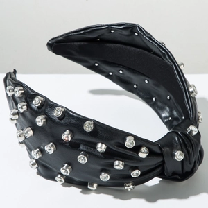 Close-up of wide black leather headband with sparkling rhinestones and knot detail