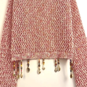 Pink hollow crochet knit top featuring shell pendants and tassel bead fringe detail