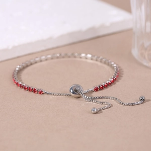 Macro detail of silver adjustable snake chain bracelet with sparkling red zircons