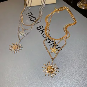 Layered gold and silver necklaces featuring starfish and sun charms in a vintage style