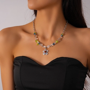 Gros plan d'un collier pendentif fleur en perles de verre porté par un mannequin