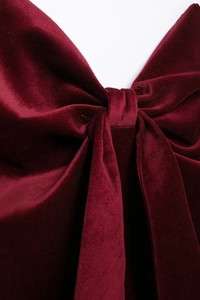 Vue macro détaillée du tissu en velours rouge foncé et du nœud sur ce haut bustier chic