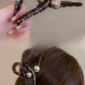 Detail of elegant hair claw clip with pearls and rhinestones on a high-end resin base