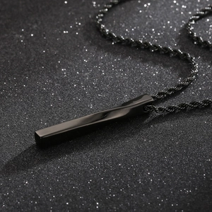 Detail of a black twisted bar pendant made of titanium steel with a woven cord chain